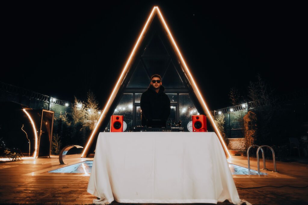 DJ performs at an illuminated venue with vibrant lighting and modern decor, creating a lively atmosphere.
